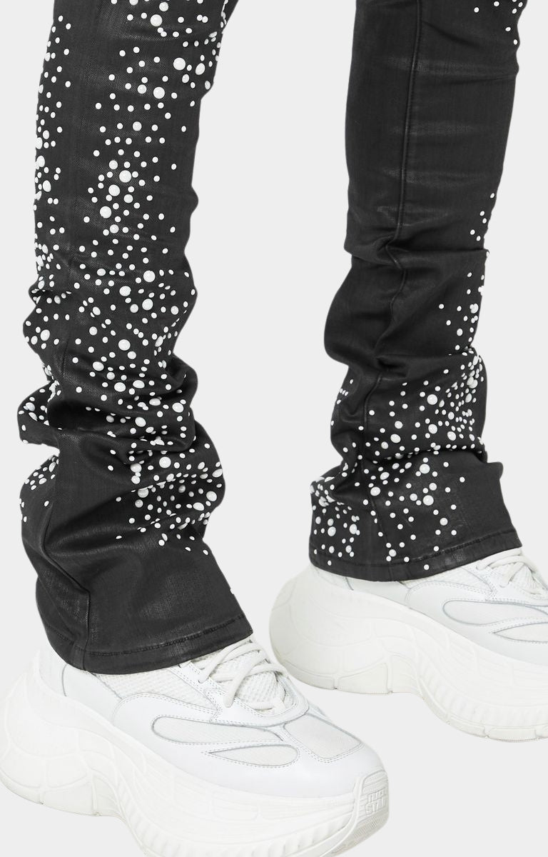 Close-up of gradient pearl stud details on black denim.