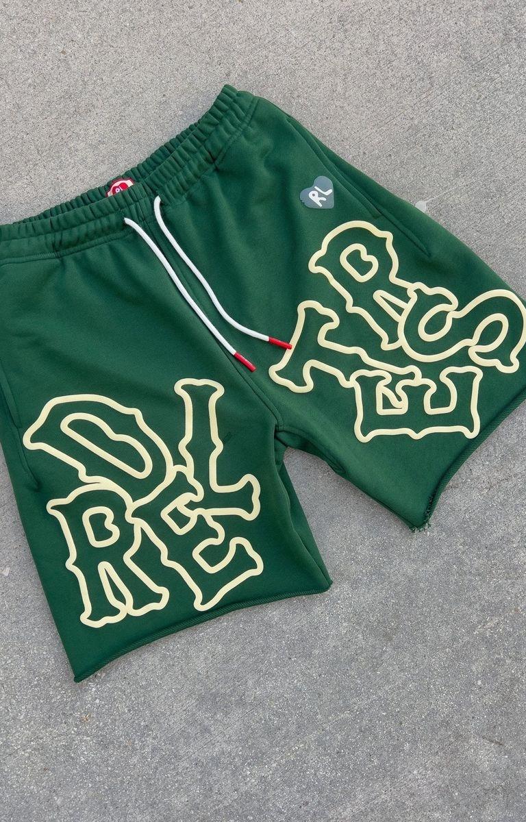 Close-up of bone-style Red Letters logo on green French terry sweat shorts.