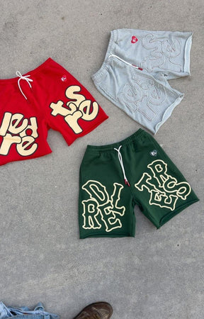 Close-up of hand-frayed distressed hem on green Red Letters sweat shorts