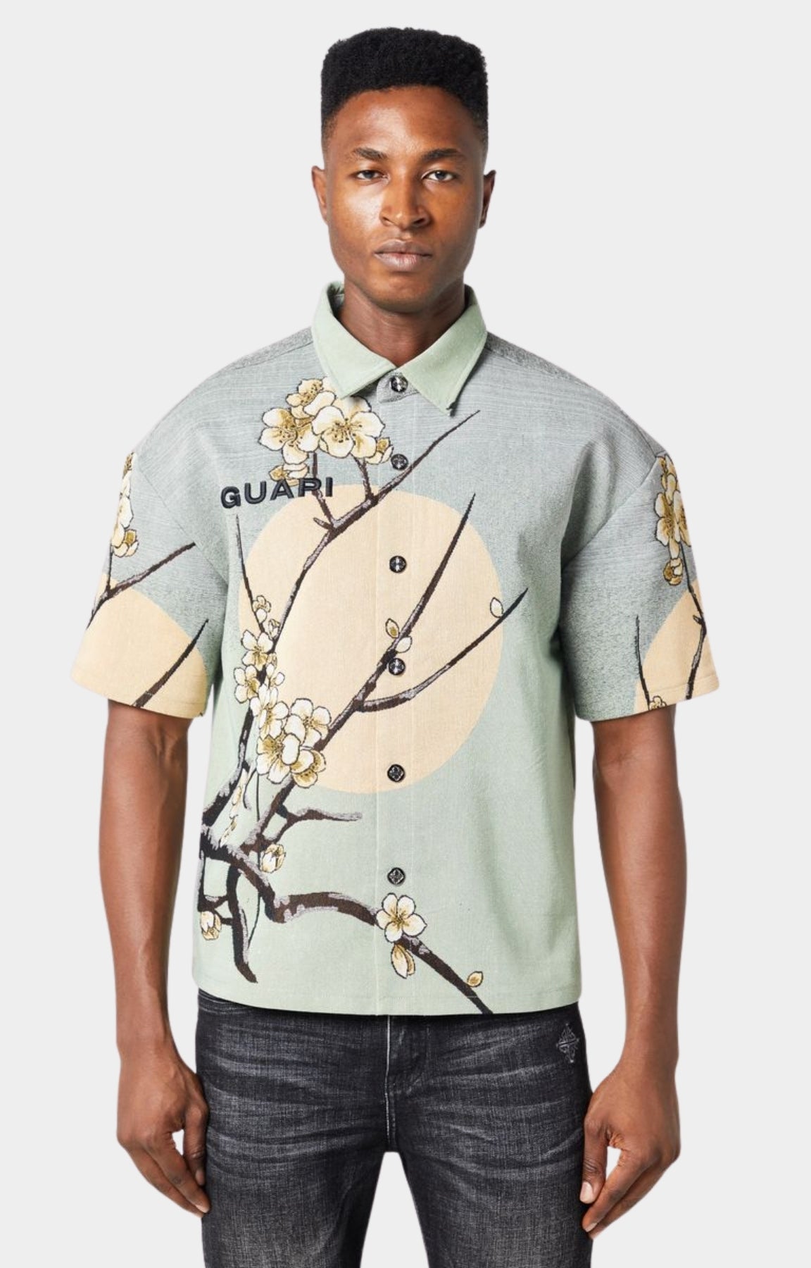 Guapi men’s tapestry floral button-down shirt in pastel green with cherry blossom design, modeled against white background