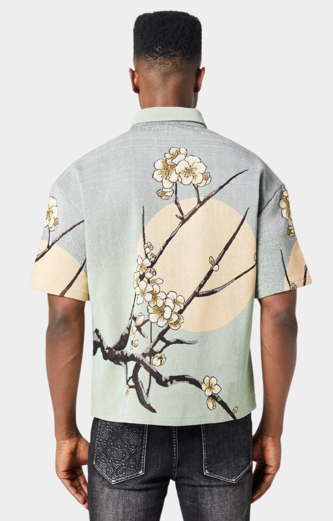 Guapi men’s tapestry floral button-down shirt in pastel green with cherry blossom design, modeled against white background.