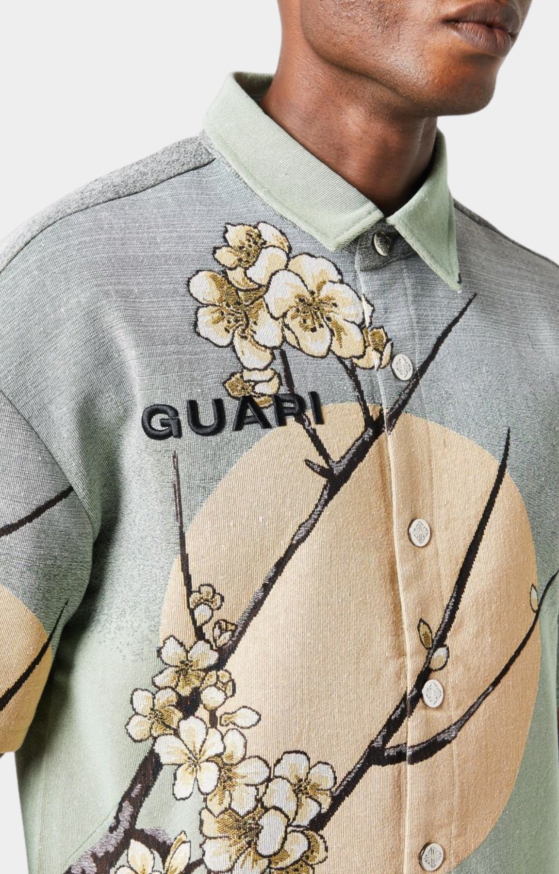 Guapi men’s tapestry floral button-down shirt in pastel green with cherry blossom design, modeled against white background