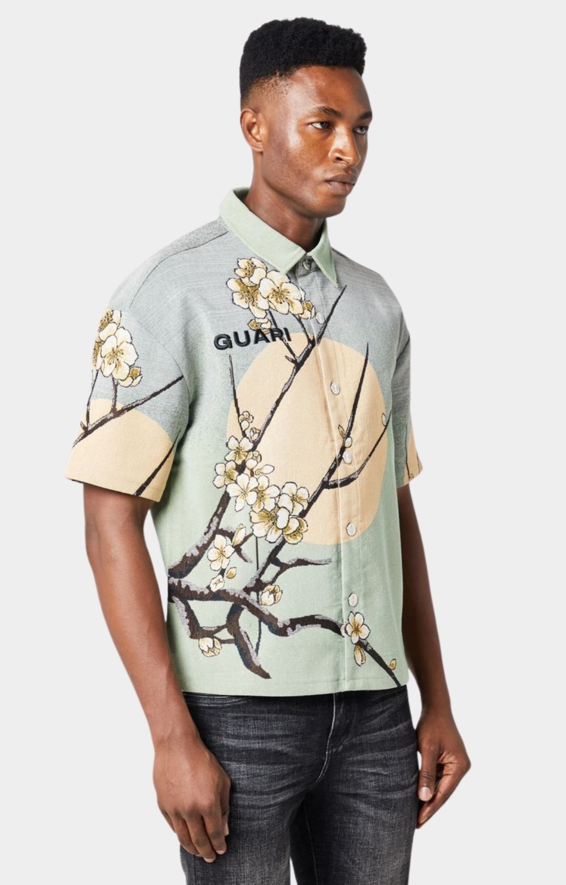 Guapi men’s tapestry floral button-down shirt in pastel green with cherry blossom design, modeled against white background