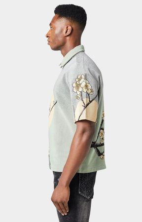 Guapi men’s tapestry floral button-down shirt in pastel green with cherry blossom design, modeled against white background