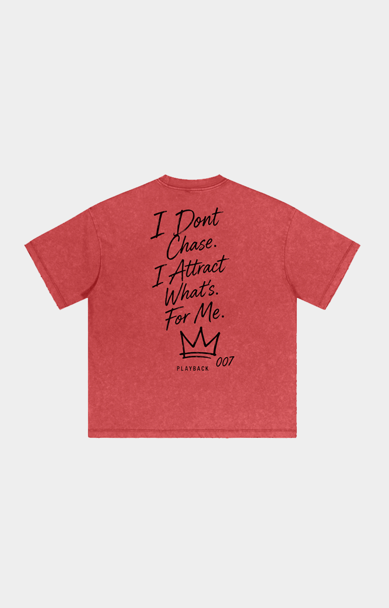 Drip Trap red heathered short-sleeve t-shirt shown from the back, featuring black text that reads 'I Dont Chase. I Attract What's For Me.