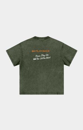Drip Trap olive green acid-wash t-shirt shown from the back, featuring an orange and white graphic print on the upper back with the text 'PLAYBACK' and 'Press Play On The Life You Want'.