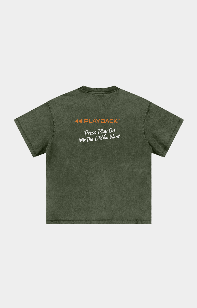 Drip Trap olive green acid-wash t-shirt shown from the back, featuring an orange and white graphic print on the upper back with the text 'PLAYBACK' and 'Press Play On The Life You Want'.