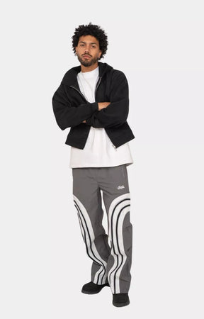 Model walking in EPTM grey nylon track pants lifestyle shot.