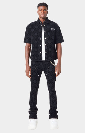 Model wearing Guapi All Black Monogram Velour Denim with sneakers and matching shirt.