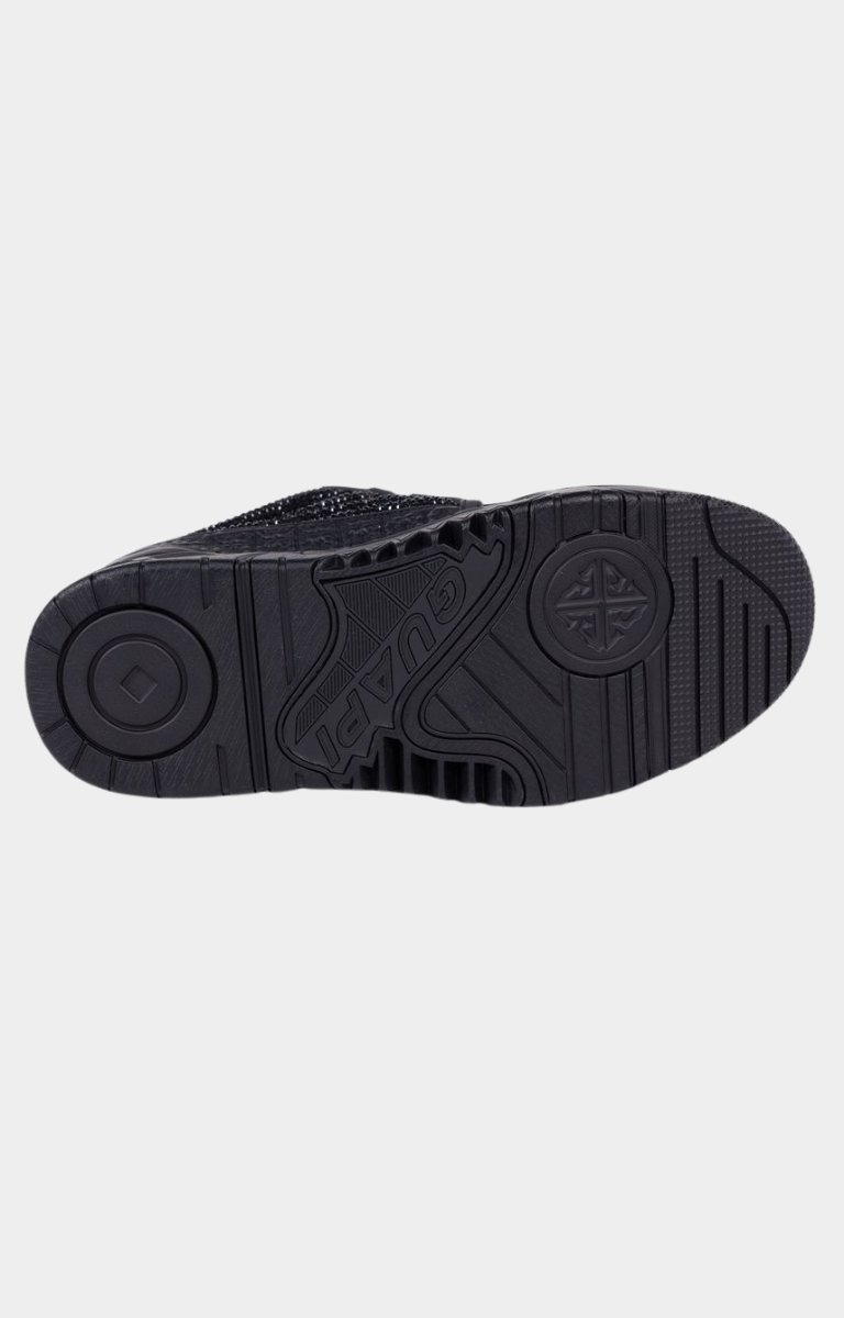 Deep tread outsole detail on black sneaker.