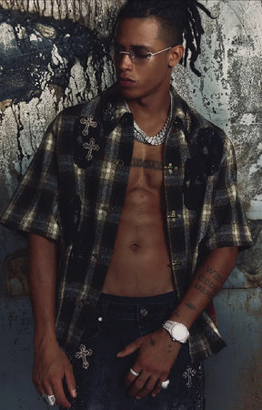 The Guapi Ash Tartan Shirt in Ash Brown combines muted tartan plaid with cream, black, and deep red accents. Designed with a relaxed short-sleeve silhouette, decorative toggle-style fastenings, skull appliqués, and embellished cross details, this statement shirt brings a gothic-inspired edge to contemporary streetwear outfits.