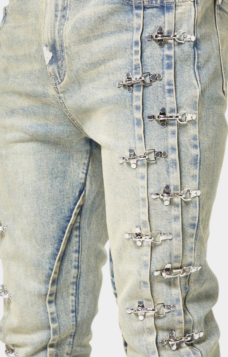 Aviation metal clasp detail along denim seam.