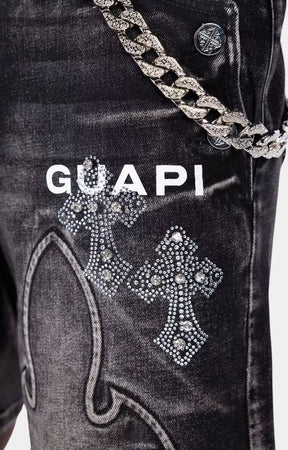 Close-up detail of Guapi Obsidian Black Faded Cross denim shorts with metallic chain. 