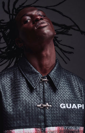 Guapi Obsidian Plaid Aviation Shirt featuring a black textured upper, black and red plaid body, metallic toggle-style closures, pointed collar and short sleeves.