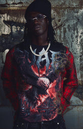 The Guapi Blood Eagle Flannel Tee in Black/Red combines a black graphic tee body with red and black plaid flannel sleeves for a distinctive layered look. Featuring bold eagle, skull, and flame-inspired artwork with decorative embellishments, this relaxed-fit statement top pairs with denim, cargo pants, and alternative streetwear outfits.