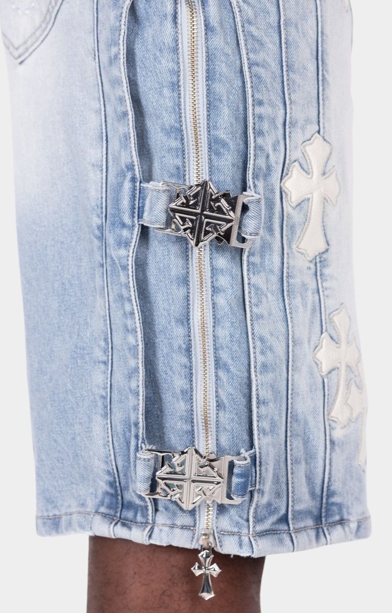 Designer denim shorts with utility buckle straps and metal hardware.