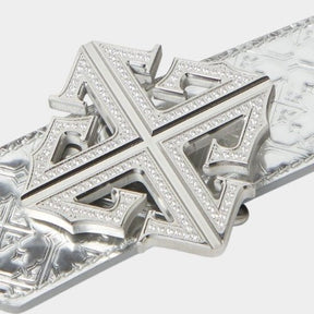 Close-up of crystal-encrusted cross buckle on chrome leather belt