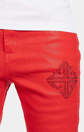 Close-up detail of Guapi icon embellishments on crimson red denim