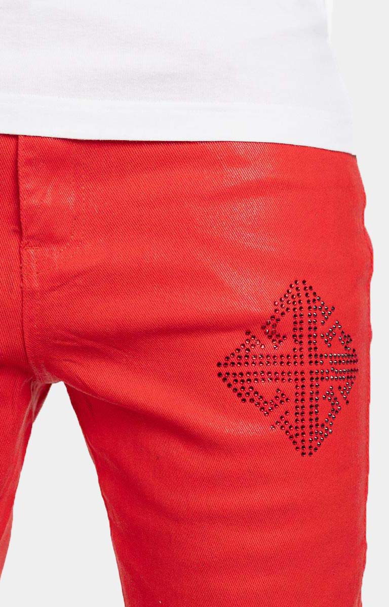 Close-up detail of Guapi icon embellishments on crimson red denim