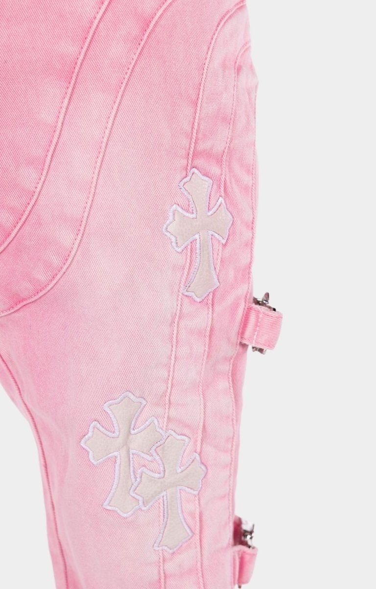 Stacked denim jeans featuring signature cross appliqué detailing.