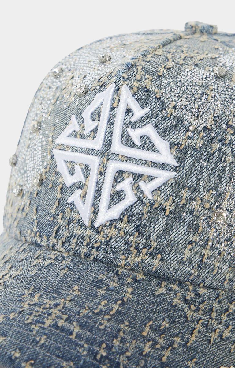 Close-up of 3D embroidered GUAPI cross logo on denim cap.