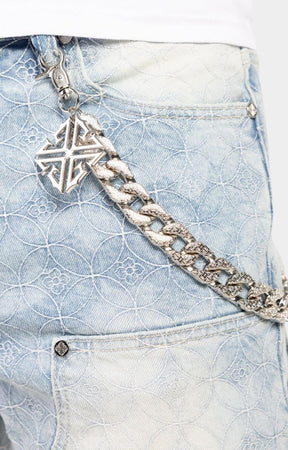 Detachable silver chain with GUAPI charm on denim.