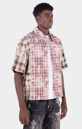Close-up detail of distressed plaid fabric and rhinestone accents.