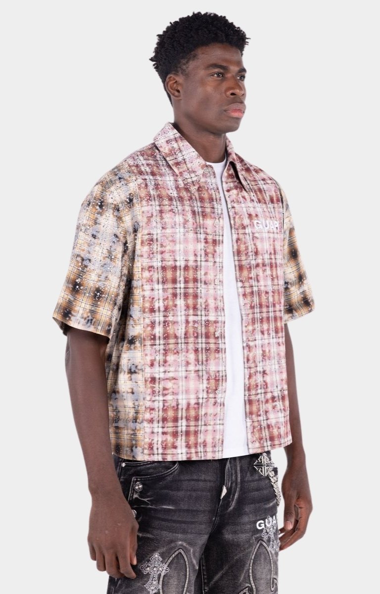 Close-up detail of distressed plaid fabric and rhinestone accents.