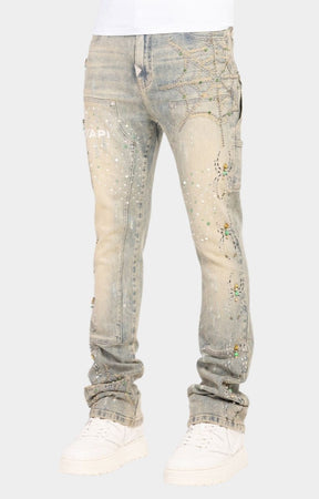 Guapi stacked denim jeans featuring spider web-inspired rhinestone detailing.