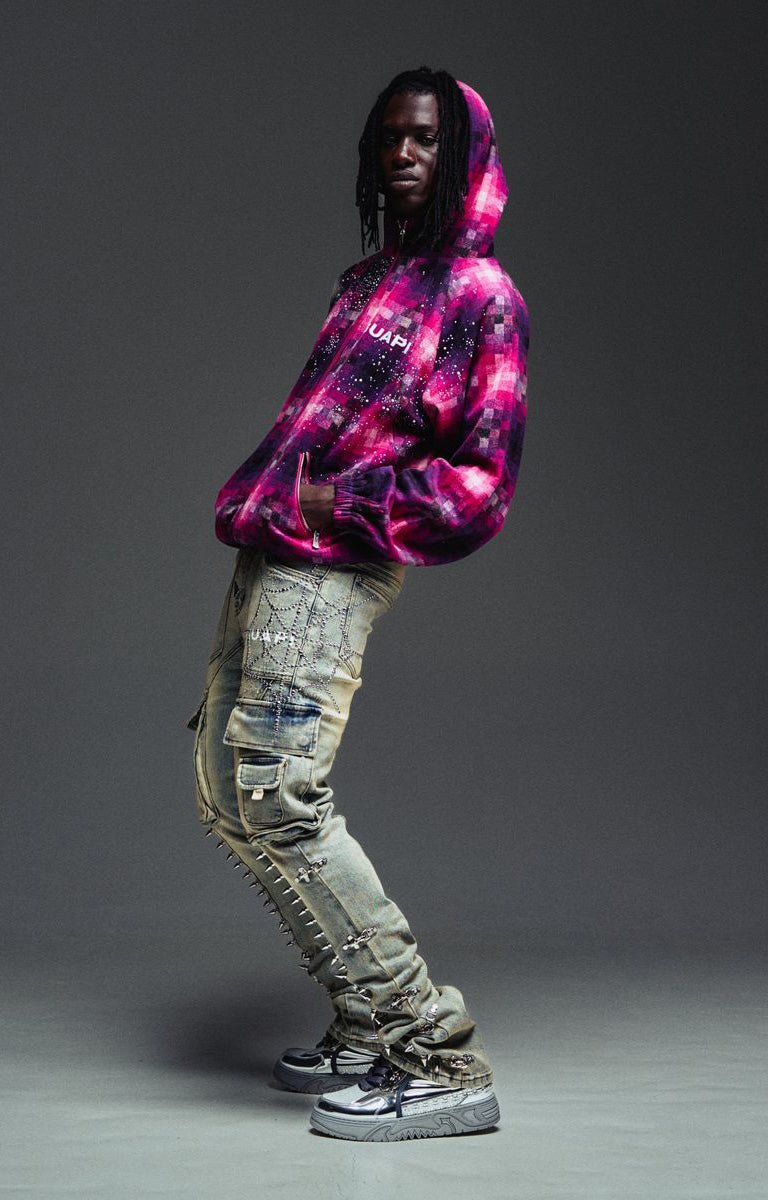 Guapi flared cargo jeans featuring spike trim heavily distressed light-wash jeans and chunky platform sneakers.