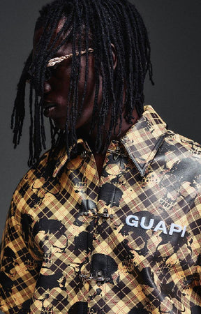 Guapi Gold Skull Plaid Leather Shirt featuring a gold-and-black plaid leather exterior, distressed skull motif, metal toggle closures, chest logo detail and relaxed boxy fit.