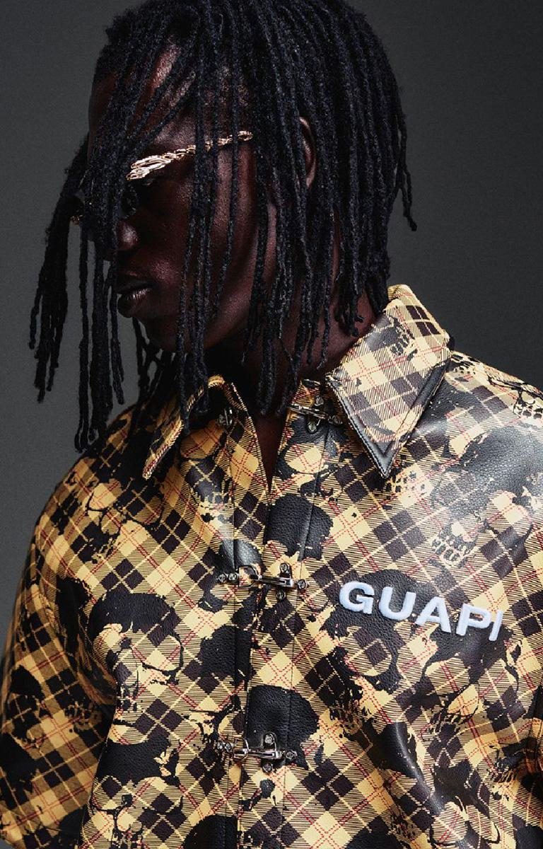 Guapi Gold Skull Plaid Leather Shirt featuring a gold-and-black plaid leather exterior, distressed skull motif, metal toggle closures, chest logo detail and relaxed boxy fit.