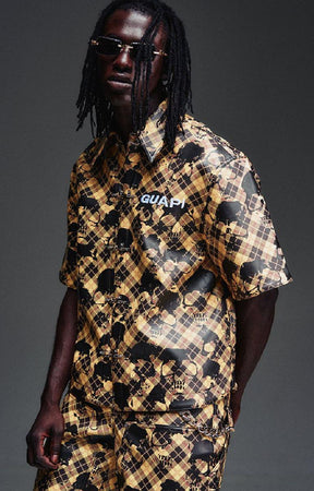 Guapi Gold Skull Plaid Leather Shirt featuring a gold-and-black plaid leather exterior, distressed skull motif, metal toggle closures, chest logo detail and relaxed boxy fit.
