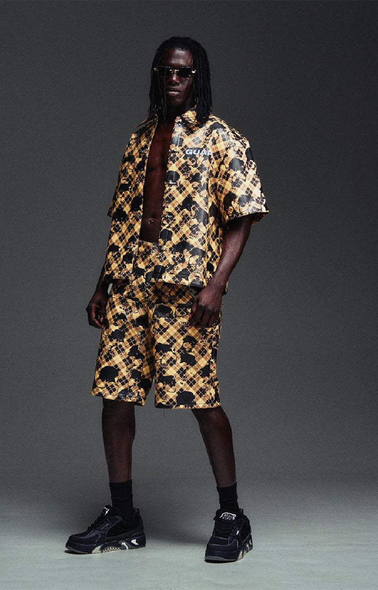Guapi Gold Skull Plaid Leather Shirt featuring a gold-and-black plaid leather exterior, distressed skull motif, metal toggle closures, chest logo detail and relaxed boxy fit.