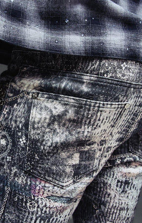 Close-up detail of spider-inspired graphics and embellishments on Guapi denim.
