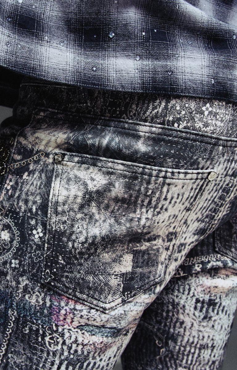 Close-up detail of spider-inspired graphics and embellishments on Guapi denim.