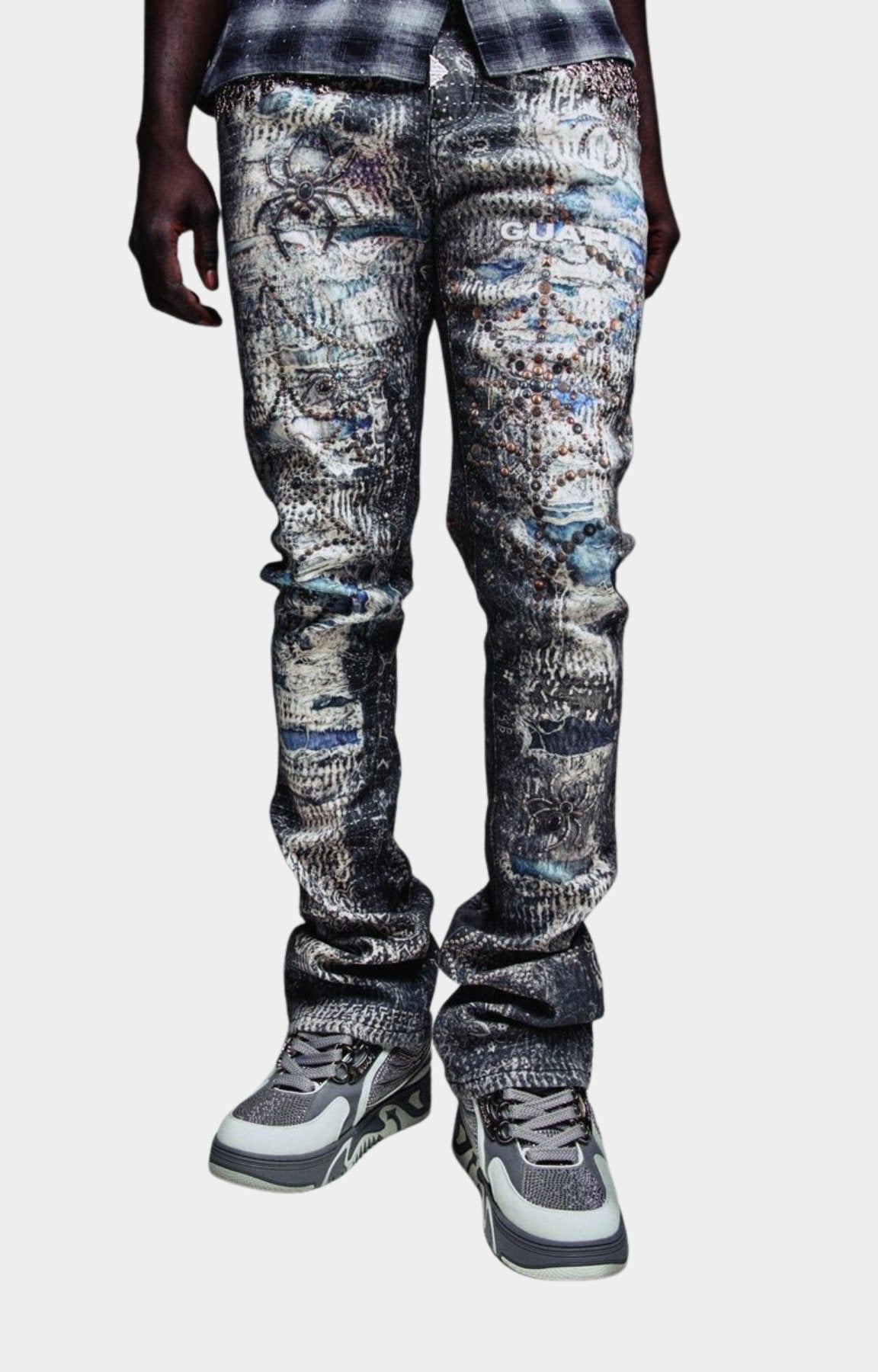 Guapi Hakai Spider Denim slim-fit jeans with a distressed, graffiti-style print in shades of blue, gray, and white. 