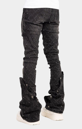 Snap button accents on lower leg of guapi black coffin arc embellished denim. 