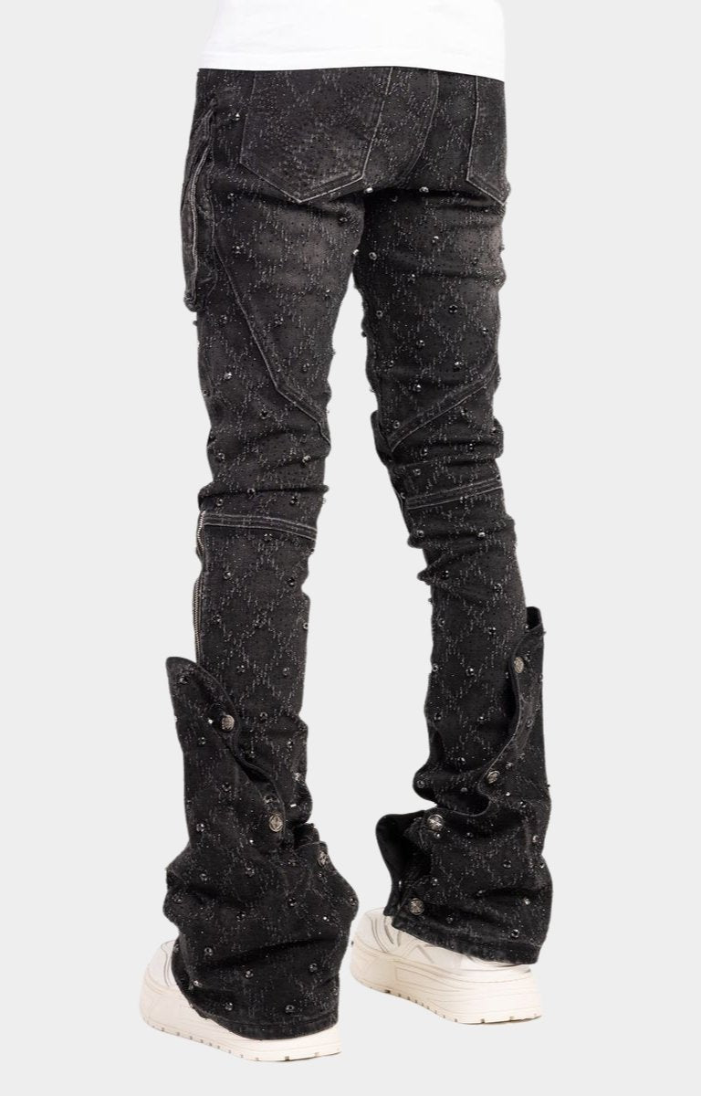 Snap button accents on lower leg of guapi black coffin arc embellished denim. 