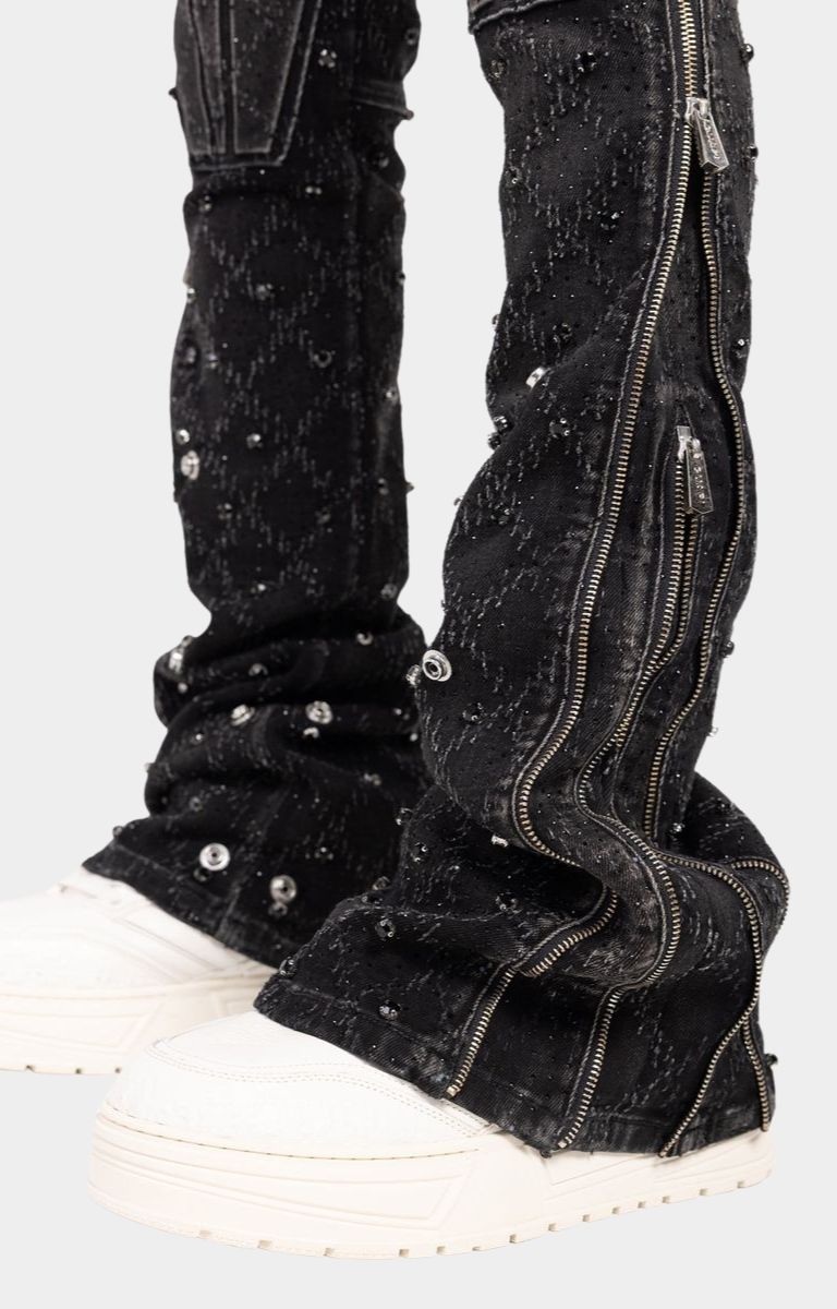 Side zipper detail on flared leg of guapi black coffin arc embellished denim. 