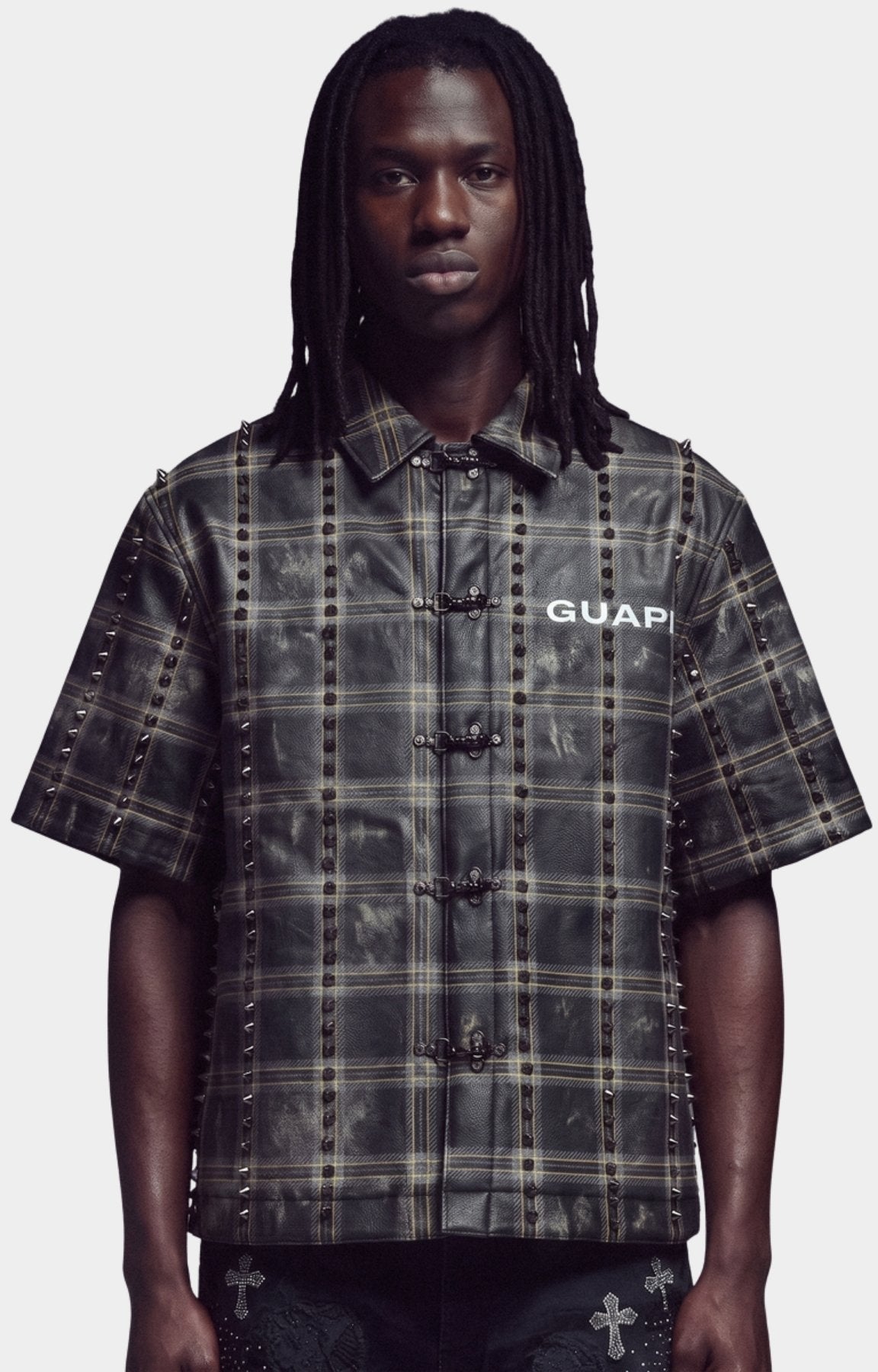 Guapi Obsidian Black No Hugs Shirt - short-sleeve button-up shirt with a distressed black and beige plaid pattern, studded details, and a front snap closure. 