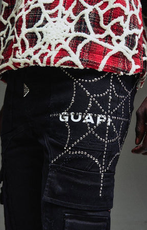 Close-up of Guapi Obsidian Black cargo denim with silver hardware, spider web with rhinestone. 