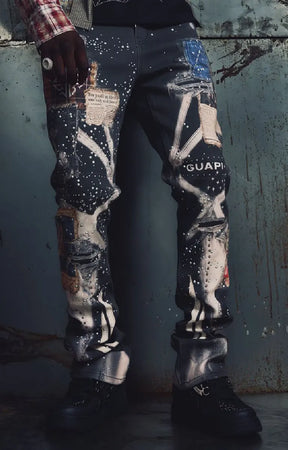 Guapi Vintage Black Chronicle Denim featuring a black base, multicolor collage-inspired prints, splatter effects, slim tailored fit, five-pocket construction and button-zip closure.