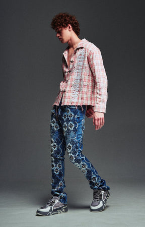 Guapi Vintage Blue Relic Denim featuring a vintage wash, distressed patchwork, cross-inspired appliqué, slim thigh fit, subtle flare leg, and metallic detailing.