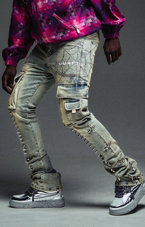 Guapi vintage grey denim with metal spike detailing heavily distressed and embellished light-wash denim cargo jeans with silver studs, chain details, and rhinestone embroidery.