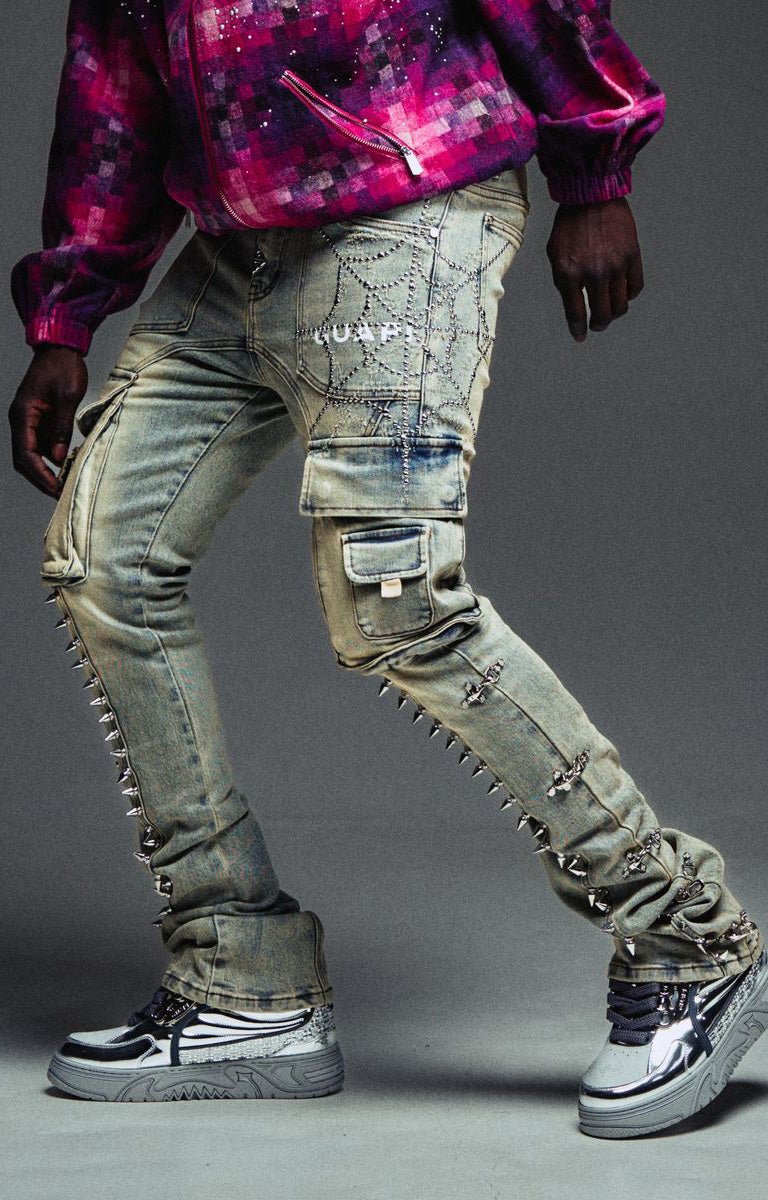 Guapi vintage grey denim with metal spike detailing heavily distressed and embellished light-wash denim cargo jeans with silver studs, chain details, and rhinestone embroidery.