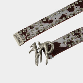Close-up of buckle and skull detail on Hyde Park cow print belt.