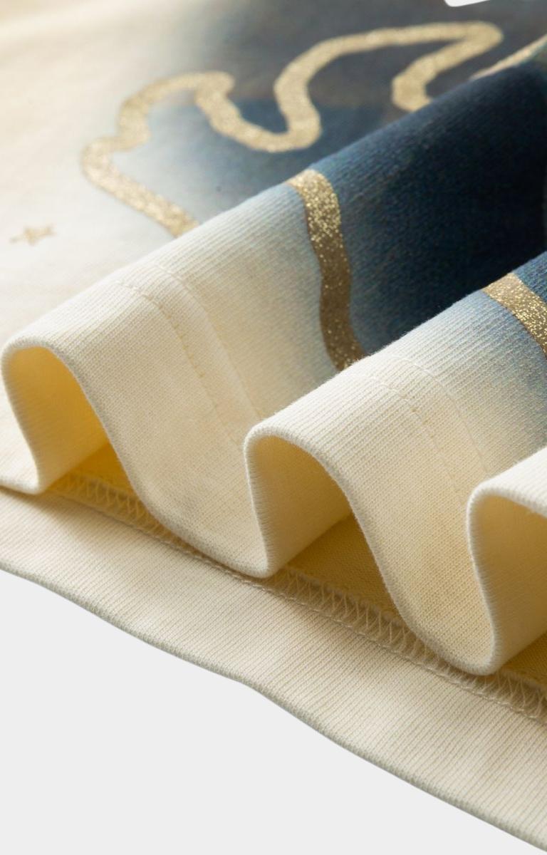 Close-up of a textured fabric with blue, gold, and beige colors on a light background.