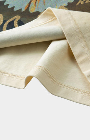 Close-up of Hyde Park Motor Park Tee in beige fabric with visible stitching on a light gray background