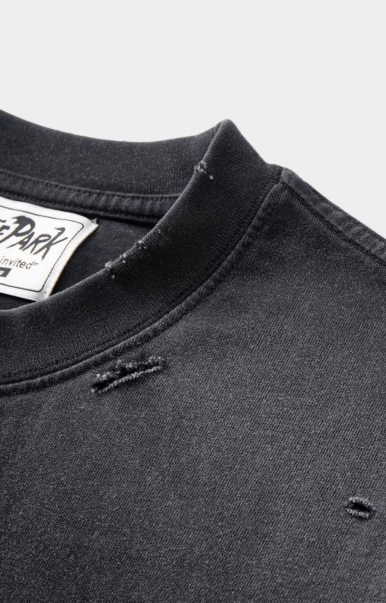 close up of distressed crew neck of oversized black distressed t-shirt